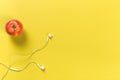 Single red color apple and digital audio headphones on yellow background, top view Royalty Free Stock Photo