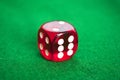 Single red dice on green background Royalty Free Stock Photo