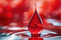 A single red drop of water sits on the surface of a larger body of water Royalty Free Stock Photo