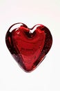 A single red heart shaped glass object placed on a white surface, ideal for decoration or gift giving Royalty Free Stock Photo