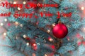 Single Red Ornament hanging from pine tree with glowing lights  in vinatage format plus text Royalty Free Stock Photo