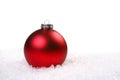 Single Red Shiny Christmas Ornament in the Snow Royalty Free Stock Photo