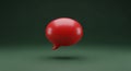 Single Red Speech Bubble Icon Floating Against a Dark Green Gradient Background with Subtle Lighting Royalty Free Stock Photo
