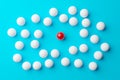 Single red sphere in the middle of group or team of white spheres over blue background, team, leadership or individuality concept