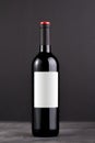 Single red wine bottle with blank label for mockup on dark gray background Royalty Free Stock Photo