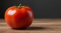 Single Ripe Red Tomato on Wooden Table Against Dark Background Royalty Free Stock Photo