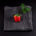 Single ripe strawberry on a napkin and slate plate kitchen table Royalty Free Stock Photo