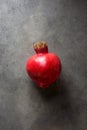 Single Ripe Vibrant Red Pomegranate on Black Stone Background Conceptual Fall Autumn Thanksgiving Harvest