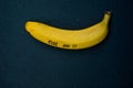 Yellow ripe banana on a black stone table background with writt