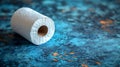 Single roll of white toilet paper on a blue textured surface Royalty Free Stock Photo