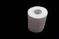 Single roll of white toilet paper. Isolated on black background. Close-up. Copy space Royalty Free Stock Photo