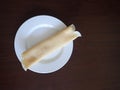 Single rolled pancake on a white plate