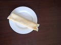 Single rolled pancake on a white plate