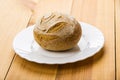 Single rye bun in white plate on table Royalty Free Stock Photo