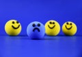 Blue sad ball and happy yellow balls stock images
