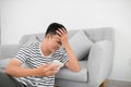 Single sad man checking mobile phone sitting on the floor in the living room at home Royalty Free Stock Photo