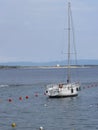 Single sailboat lies at anchor in a harbor waiting for the wind to shift . Tuscany, Italy Royalty Free Stock Photo