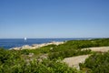 A single sailboat off the coast on a clear sunny day