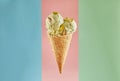 Single scoop of pistachio ice cream in a waffle cone isolated on three pastel color background Royalty Free Stock Photo