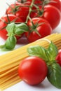 Single serving of spaghetti with focus on fresh tomatoes and basil, presented on white background Royalty Free Stock Photo