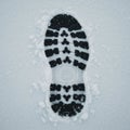 A single shoe print is clearly visible on a fresh layer of snow. The black tread pattern is Royalty Free Stock Photo