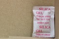 Single Silica gel packet in the bottom corner of a cardboard box.