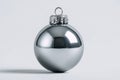 A single silver shiny Christmas ornament sits centered on a plain white background with its hanging loop visible. Royalty Free Stock Photo