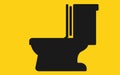 A single sitting flush toilet set against a yellow backdrop Royalty Free Stock Photo