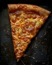 Single Slice of Cheese Pizza With Melted Cheese and Spices on Black Pan Royalty Free Stock Photo