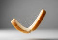 A single slice of white bread is captured mid-air, bent into a curved shape against a plain gray Royalty Free Stock Photo