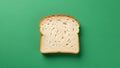 A single slice of white bread is centered on a solid green background Royalty Free Stock Photo