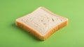 A single slice of white bread rests on a solid green background Royalty Free Stock Photo