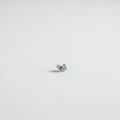 A single, small blue earplug rests on a plain white surface. The earplug is cylindrical wit Royalty Free Stock Photo