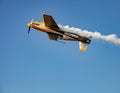 Single small propeller airplane performing aerobatics with smoke trails