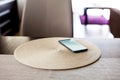 Single smartphone left on the table in the living room, one unattended mobile phone device laying on a coaster screen on Royalty Free Stock Photo