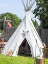 A single, solitary teepee in a field. Teepees are used in many summer camps as shelter for the campers.