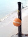 single sphere mooring buoy or fishing tool hanging on bamboo wooden pole of corner pier Royalty Free Stock Photo