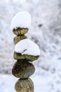 Single stack of snow covered round rocks in a peaceful snowy zen garden