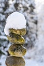 Single stack of snow covered round rocks in a peaceful snowy zen garden