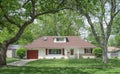 Single Story House with Red Accents Surrounded by Large Trees Royalty Free Stock Photo