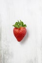 Single strawberry on wooden background Royalty Free Stock Photo