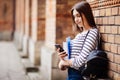 Single student walking and reading mobile phone messages with a university building in the background Royalty Free Stock Photo