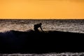Surfer at sunset on a calm ocean Royalty Free Stock Photo