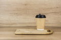 Paper cup of coffee on wooden table