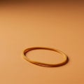 A single, tan rubber band lies on a smooth, beige surface. The band is circular and Royalty Free Stock Photo