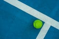 Single tennis ball on blue tennis court Royalty Free Stock Photo