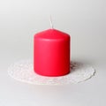 Single thick pink aromatic candle on white openwork paper napkin on gray background side view Royalty Free Stock Photo