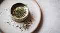 A single tin of oregano styled with a small pinch of dried herbs on a Royalty Free Stock Photo