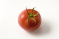 Single Tomato with Stem Isolated on White Background. Top view. Royalty Free Stock Photo