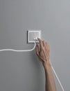 Hand Activating a Glowing Light Switch on a Gray Wall Royalty Free Stock Photo